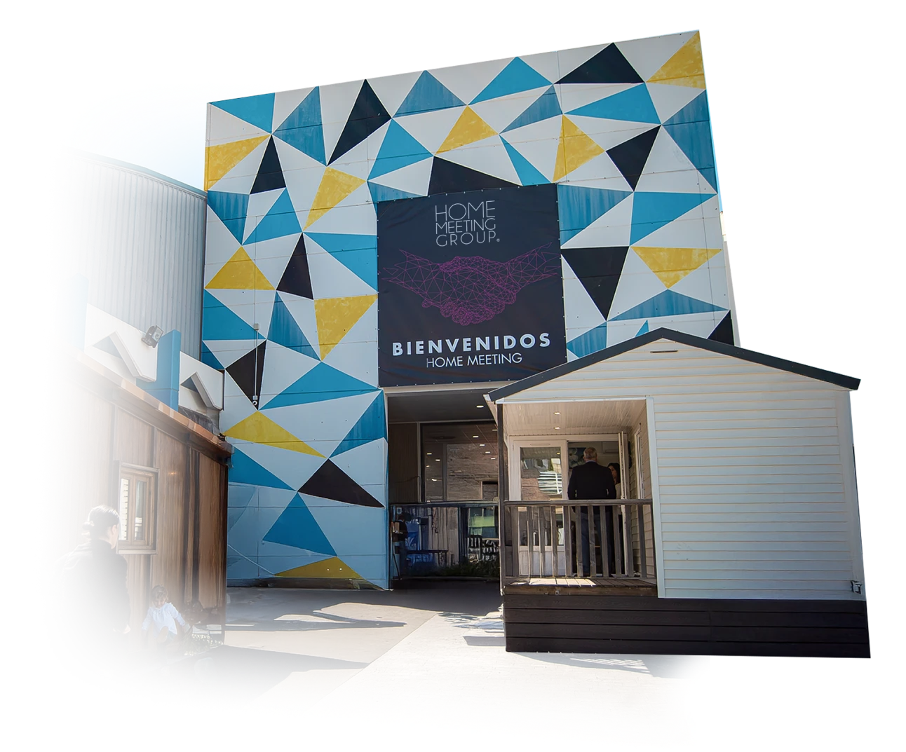 Entrance of the Home Meeting Group 2026 event in Marbella, featuring the Bienvenidos Home Meeting banner and modern geometric building facade.